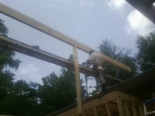 Carpenter setting a ridge beam over a new addition frame — Ice Dam Removal by Roofing Brothers in Summerhill