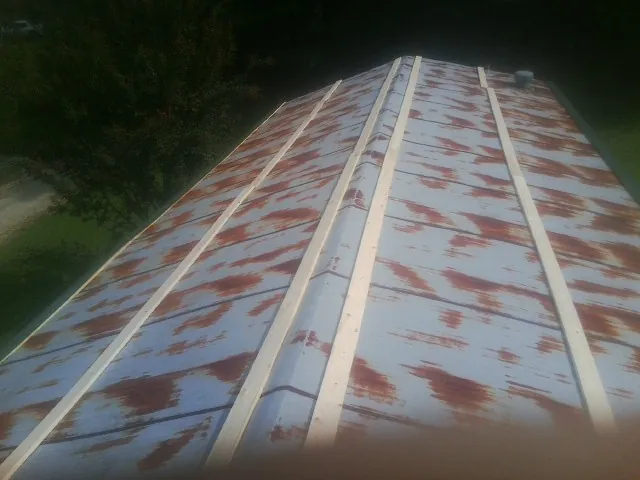 Rusted metal roof panels with new wood purlins before replacement — Storm Damage Roof Repair in Summerhill by Roofing Brothers