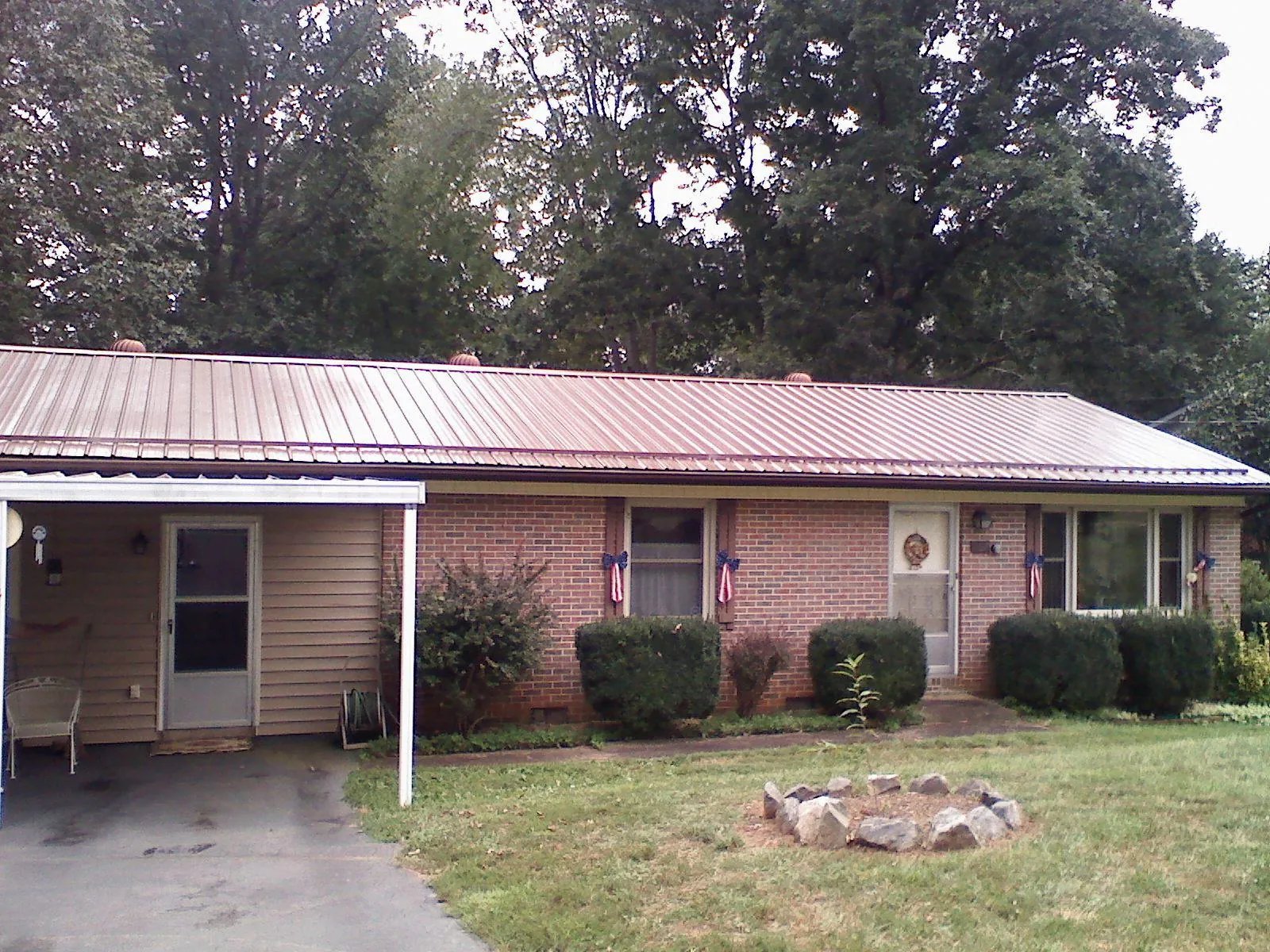 Bronze metal roof and carport on a brick ranch home — Roof Repair work by our crew in Summerhill
